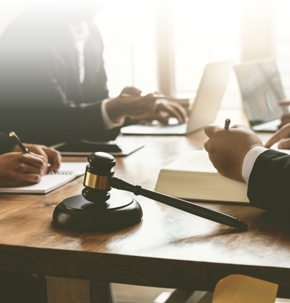 judge's gavel, people chatting on a table while filling out documents
